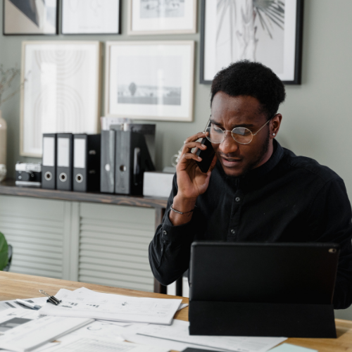 Entrepreneur martiniquais planifiant sa retraite avec conseiller, documents PER sur la table